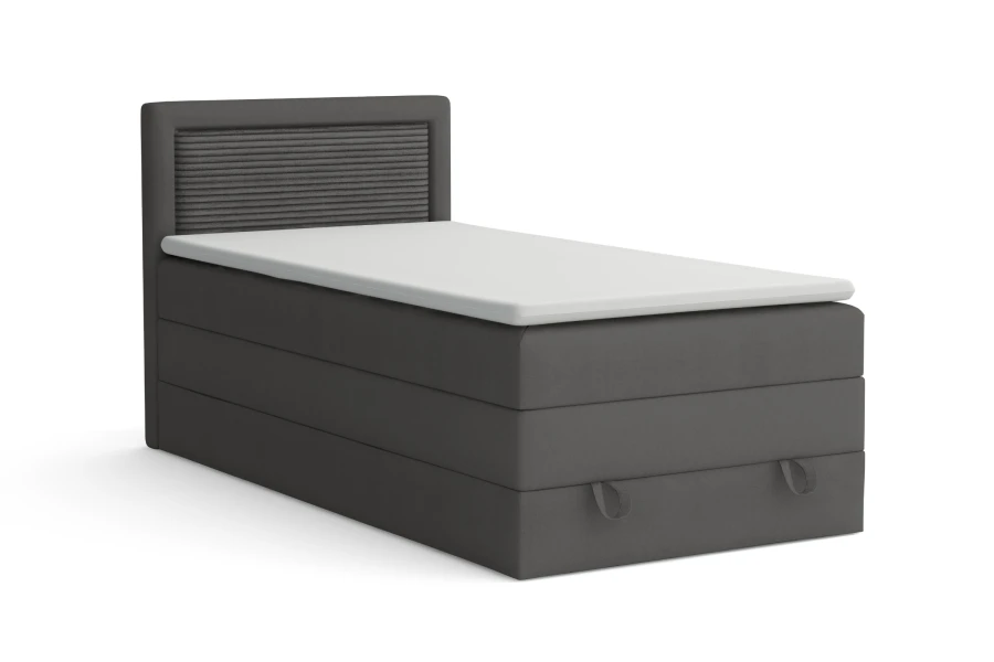 Graues Boxspringbett mit weißem Topper und Kopfteil, freigestellt auf Weiß.