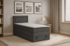 Graues Boxspringbett in gemütlichem Schlafzimmer mit Teppich und Bildern.