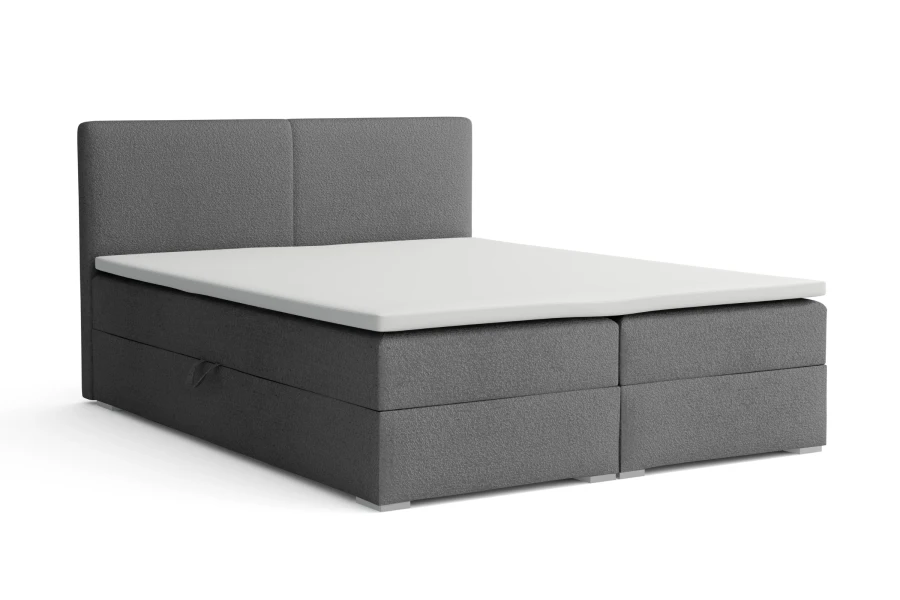 Graues Boxspringbett mit weißem Topper isoliert auf weißem Hintergrund.