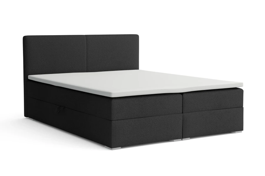 Dunkelgraues Boxspringbett mit weißem Topper und gepolstertem Kopfteil vor weißem Hintergrund.