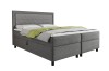 Boxspringbett in hellem Grau mit Cord-Bezug und grünem Plaid
