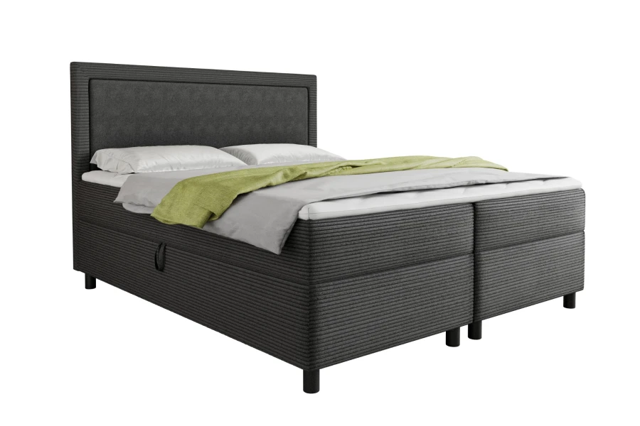 Dunkelgraues Boxspringbett in Cord-Optik mit grünem Überwurf