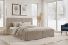 Eingerichtetes Schlafzimmer mit beigem Cord-Bett und Winterausblick