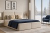 Gemütliches beiges Polsterbett im modern eingerichteten Schlafzimmer mit Winterblick.