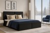 Schwarzes Polsterbett im modern eingerichteten Schlafzimmer mit Blick auf Winterlandschaft.