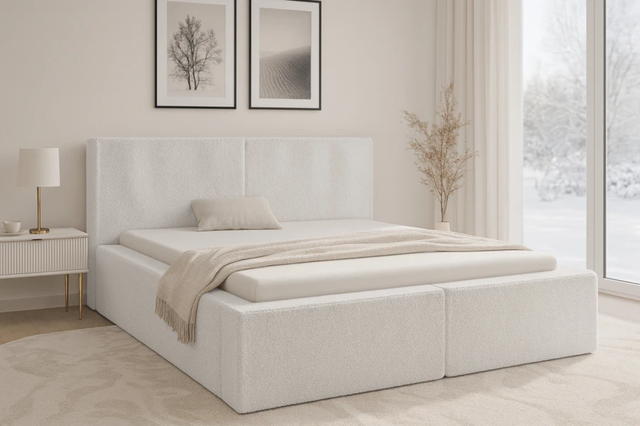Gemütlich eingerichtetes Schlafzimmer mit weißem Bouclé-Polsterbett und winterlichem Ausblick durch das Fenster.