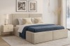 Gemütliches Schlafzimmer mit beigem Polsterbett, blauer Tagesdecke und moderner Einrichtung.