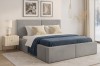 Graues Polsterbett Berno im Schlafzimmer mit blauer Bettwäsche und modernem Nachttisch.