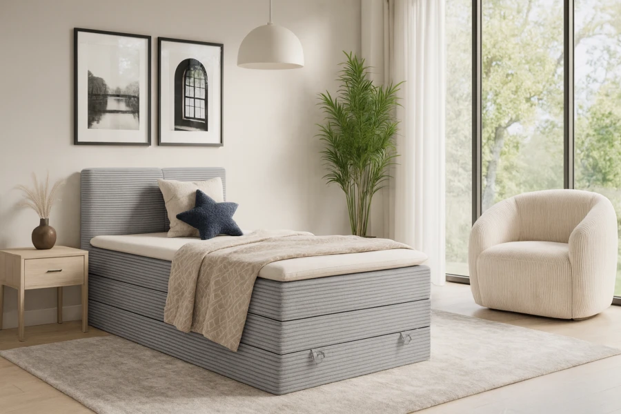 Stilvolles Schlafzimmer mit hellgrauem Cord-Boxspringbett und gemütlichem Sessel