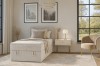 Modern bedroom ambience with beige corduroy single bed and stylish decor.