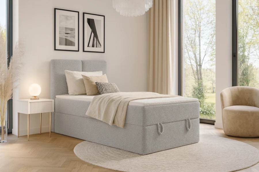 Modernes Schlafzimmer mit grauem Boxspringbett, hellem Teppich und stilvoller Einrichtung