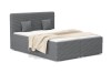 Dunkelgraues Polsterbett in Cord-Optik mit beiger Decke und Kissen.