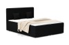 Boxspringbett in schwarzer Cord-Optik mit zwei Kissen und einer beigen Decke.