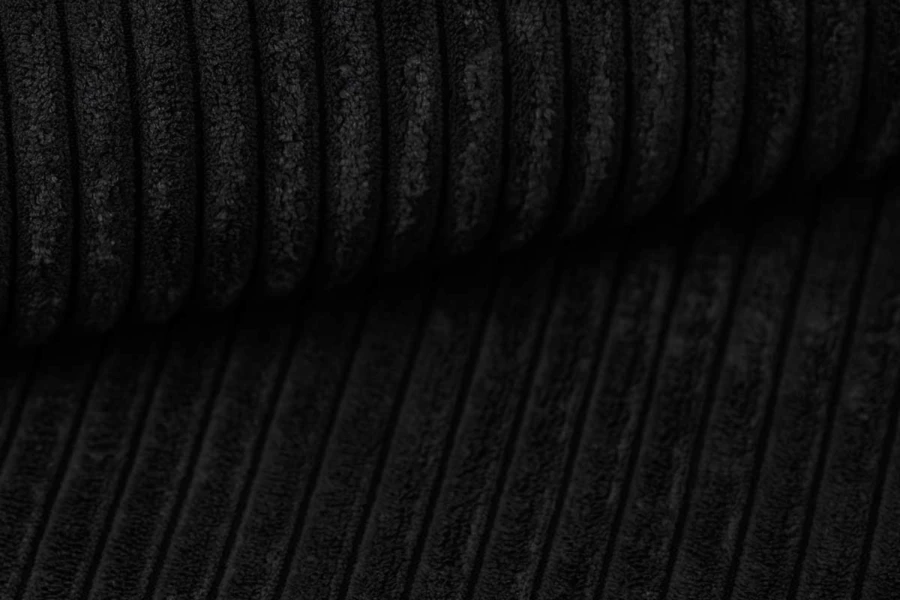 Nahaufnahme der schwarzen Cord-Stoffstruktur des Boxspringbettes.