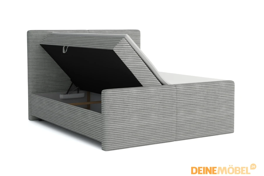 Graues Boxspringbett aus Cord-Stoff mit geöffnetem Bettkasten für extra Stauraum.