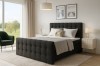 Stilvolles anthrazitfarbenes Boxspringbett in einem hellen, modern eingerichteten Schlafzimmer.