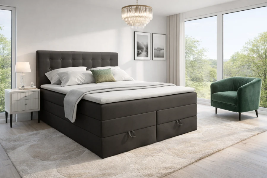 Dunkelgraues Boxspringbett mit Bettkasten in einem hellen Schlafzimmer mit Aussicht.