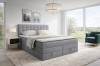 Graues Boxspringbett mit Bettkasten in modernem, hellem Schlafzimmer.