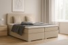 Bello Boxspringbett in Beige in einem modern eingerichteten Schlafzimmer mit Fenster und Vorhängen.