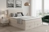 Modernes Schlafzimmer-Design mit beigem Boxspringbett, Sessel und stilvoller Beleuchtung.