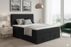 Modernes Schlafzimmer mit schwarzem Boxspringbett, Nachttisch und gemütlicher Atmosphäre.