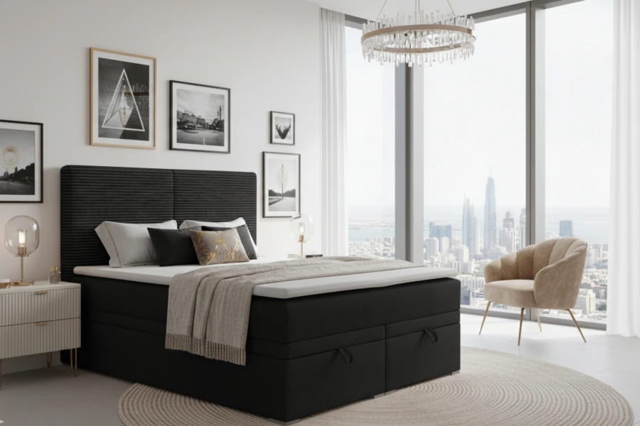 Zwart boxspringbed in modern ingerichte slaapkamer met uitzicht op de stad en comfortabele fauteuil.