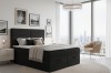 Modern zwart boxspringbed Daniel in een stijlvolle slaapkamer met uitzicht op de skyline.