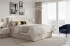 Gemütliches Schlafzimmer-Design mit hellem Doppelbett, rundem Teppich und moderner Hängelampe.