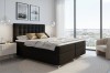Modernes Boxspringbett in Anthrazit in einem hellen Schlafzimmer mit Stadtblick und Sessel