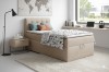 Modern bedroom set with beige boxspring bed and stylish interior.