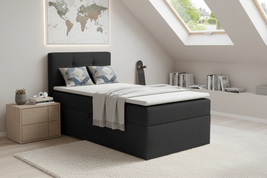 Graues Boxspring-Einzelbett mit Topper in einer hellen Mansardenwohnung mit Dachfenster.