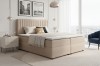 Beiges Boxspringbett mit gestepptem Kopfteil in modernem Schlafzimmer.