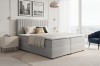 Hellgraues Boxspringbett mit gestepptem Kopfteil in modernem Schlafzimmer.