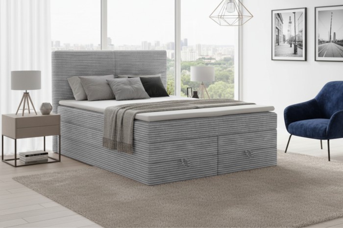 Modernes Boxspringbett in Grau mit Cord-Bezug und Bettkasten im hellen Schlafzimmer.