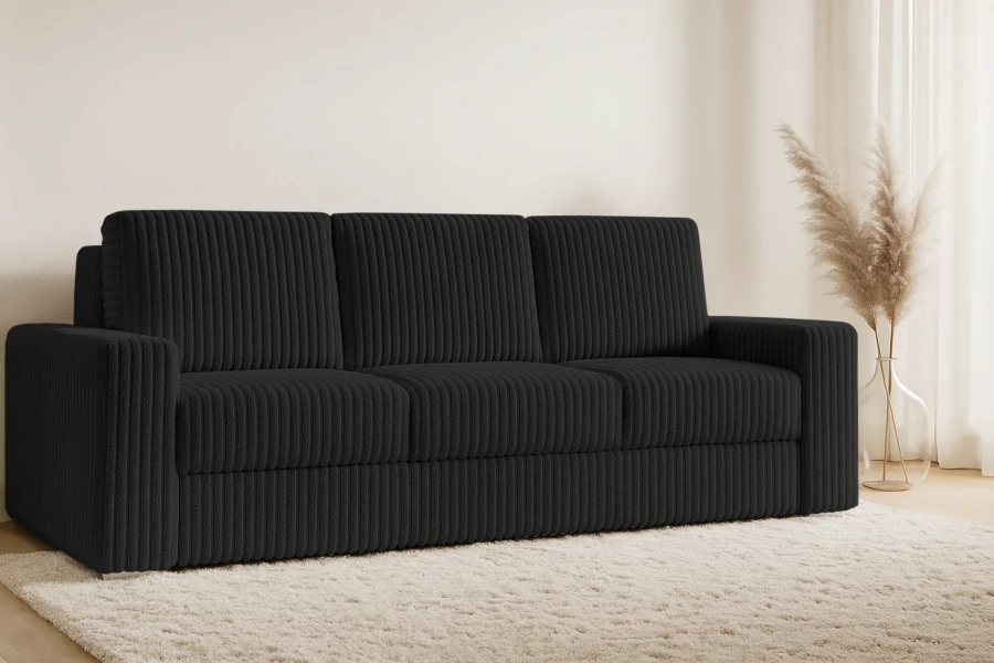 Schwarzes Cordsofa in gemütlicher Wohnzimmer-Umgebung mit Teppich