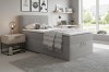 Cosy bedroom set with grey box spring bed, bedside table and modern interior design.