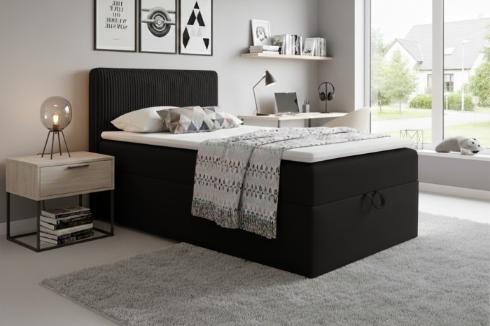 Modern slaapkamerontwerp met zwart boxspringbed, nachtkastje en licht tapijt.