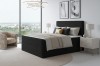 Schwarzes Boxspringbett mit strukturiertem Kopfteil in modernem Interieur.