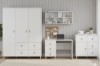 Modernes weißes Jugendzimmer-Set mit Kleiderschrank, Schreibtisch und Kommode vor Holzwand.