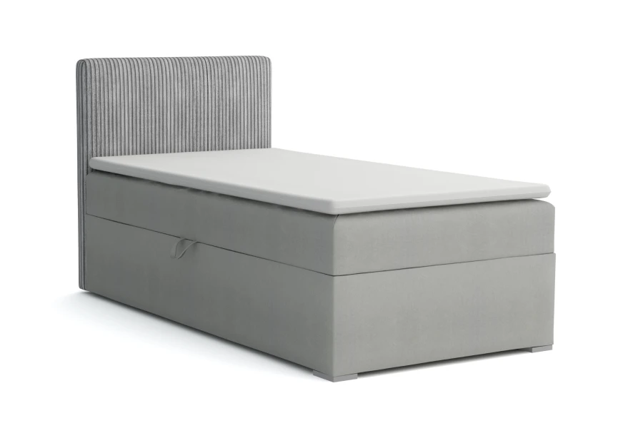 Graues Boxspringbett mit Cord-Kopfteil und weißem Topper, Einzelbett freigestellt.