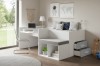 Modernes Kinderzimmer mit weißem Funktionsbett, Schreibtisch und Deko für eine gemütliche Atmosphäre.