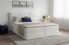 Modernes weißes Boxspringbett in einem hellen Schlafzimmer mit gemütlicher Atmosphäre.