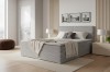 Modernes Boxspringbett in Grau mit Cord-Bezug im hellen Schlafzimmer.