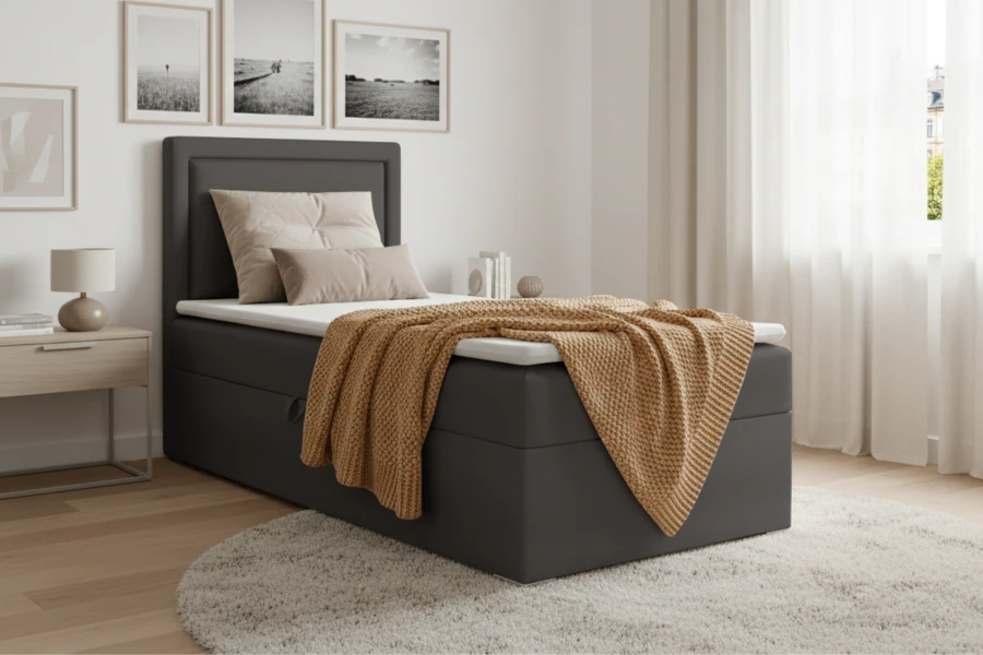 Antracietkleurig boxspringbed met opbergruimte and gele wollen deken in modern design.