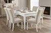 Essgruppe bestehend aus einem weißen Tisch und 6 beigen Polsterstühlen in elegantem Ambiente.
