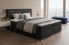 Dunkelgraues Boxspringbett mit Cord-Bezug im luxuriösen Schlafzimmer-Ambiente.