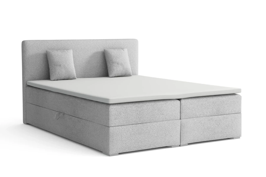 Hellgraues Boxspringbett mit Polsterkopfteil und Kissen