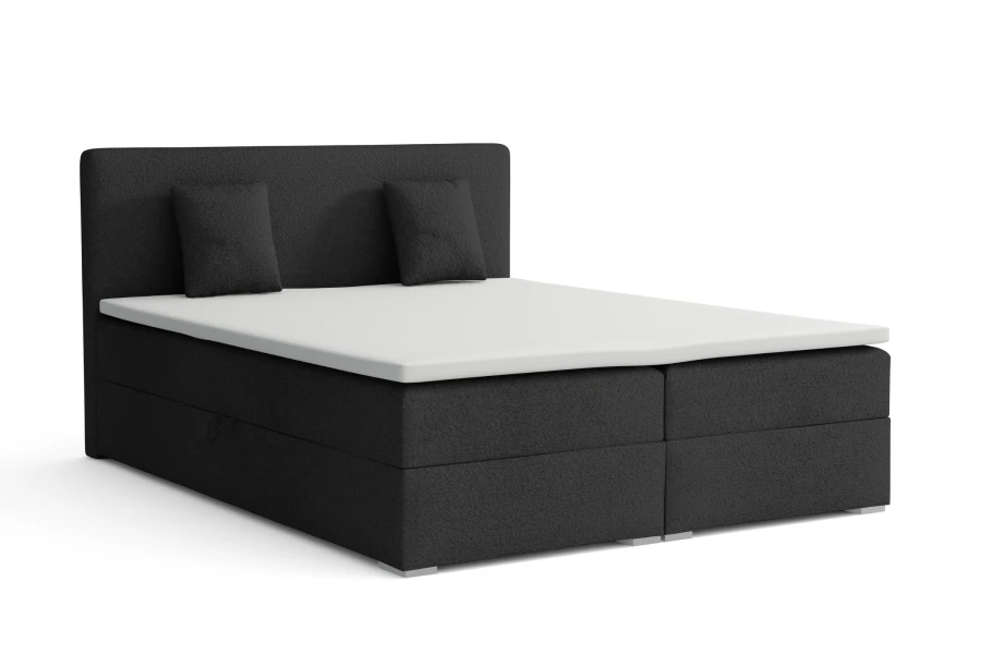 Elegantes dunkelgraues Boxspringbett mit gepolstertem Kopfteil und zwei Kissen vor weißem Hintergrund.