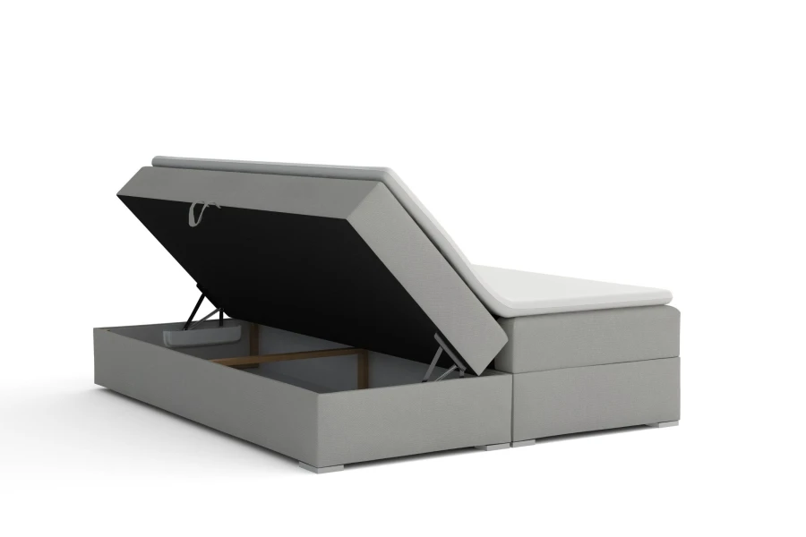 Hellgraues Boxspringbett mit praktischem, seitlich zu öffnendem Bettkasten für zusätzlichen Stauraum.
