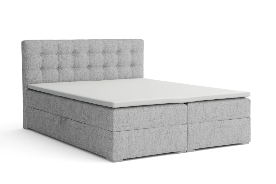 Hellgraues Boxspringbett mit gestepptem Kopfteil freigestellt